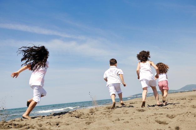 group of happy child on beach who have fun and play games