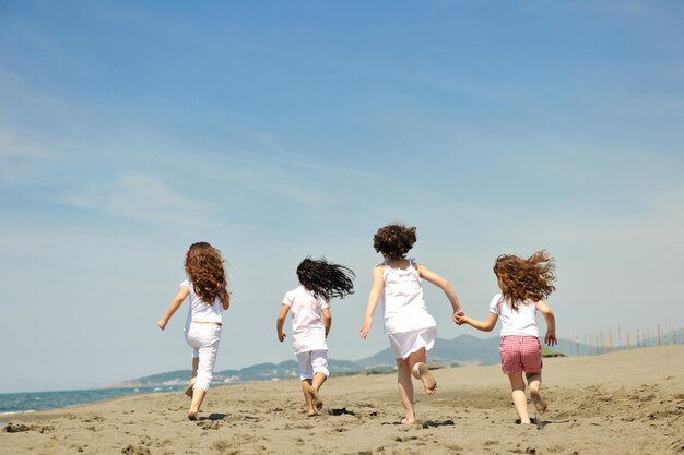 group of happy child on beach who have fun and play games