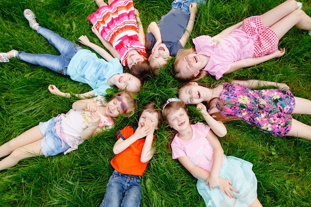 A group of happy children of boys and girls run in the Park on the grass on a Sunny summer day . The concept of ethnic friendship, peace, kindness, childhood