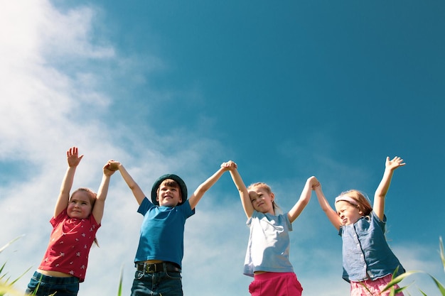 Foto un gruppo di bambini felici di ragazzi e ragazze corrono nel parco sull'erba in una soleggiata giornata estiva il concetto di amicizia etnica pace gentilezza infanzia