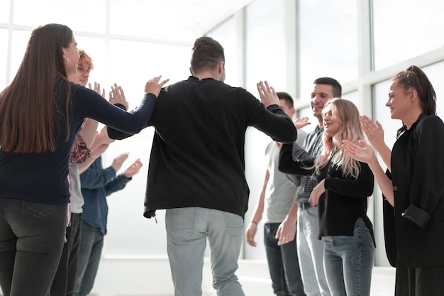 group of happy employees congratulating their colleague