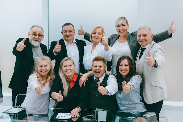 group of happy employees showing thumbs up. success concept