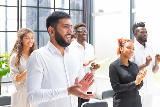 Group of happy employees standing in the office applauding