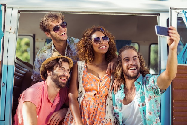 Gruppo di amico felice che prende un selfie in camper