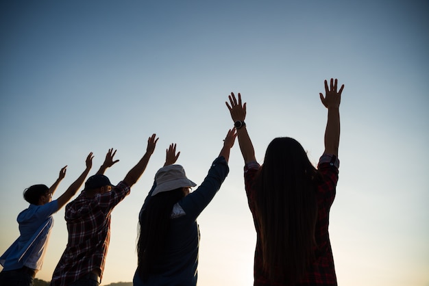 Group of happy friends are having fun with raised arms together