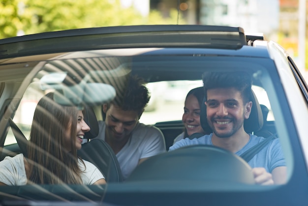 Group of happy friends on a car