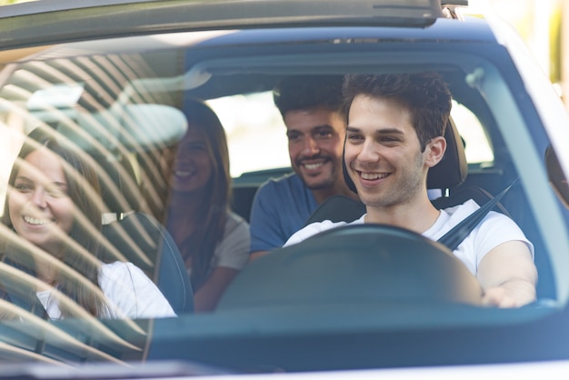 Gruppo di amici felici su una macchina