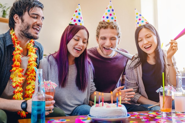 Gruppo di amici felici che festeggiano il compleanno a casa