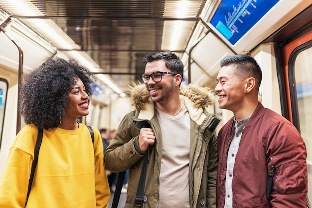 地下鉄でおしゃべりする幸せな友達のグループ。友情の概念。