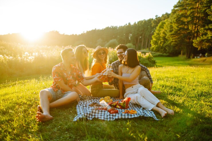 Photo group of happy friends cheers drink beers on in summer park vacation picnic holliday concept
