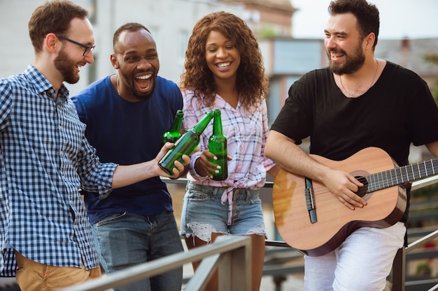 Group of happy friends having beer party in summer day
