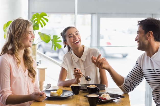 Group of happy friends having dessert together