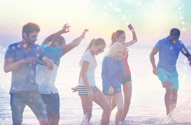 Group of happy friends having fun together on the beach