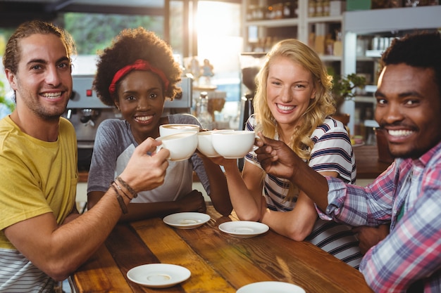 Photo group of happy friends holding cup of coffee