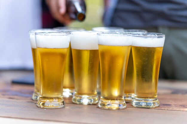 健康的なライフスタイルを生き、ビールとビールを飲みながら応援をリラックスして幸せな友人のグループ