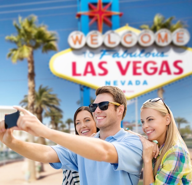 group of happy friends taking selfie by cell phone