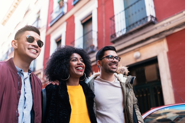 Group of happy friends walking in the street. Friendship concept.