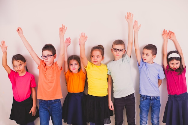 Gruppo di bambini gioiosi felici che posano insieme allo studio