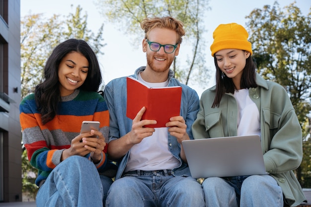 Gruppo di studenti multirazziali felici che studiano la lingua di apprendimento che si preparano per l'esame