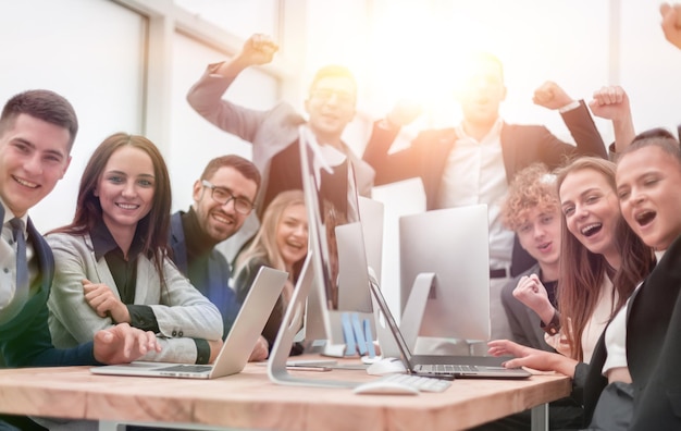 group of happy office employees sitting at a table. success concept