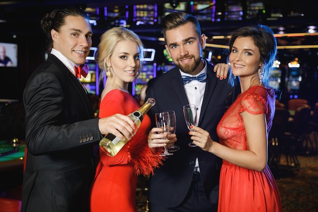 Group of happy people drinking sparkling wine in the casino