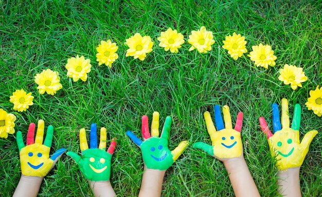 Group of happy people on green grass Family having fun in spring Smiley on hands Ecology concept Top view portrait