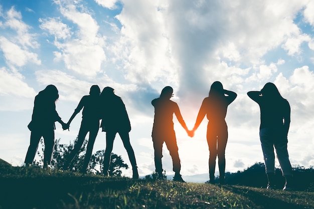 Photo group of happy people playing at summer sunset in nature