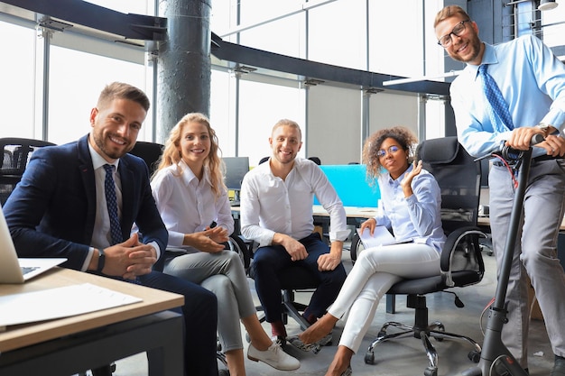 Gruppo di uomini d'affari progressisti felici che lavorano insieme all'avvio presso l'ufficio creativo