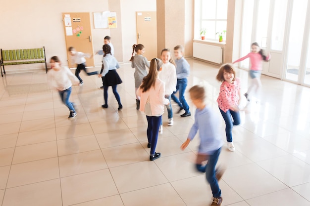 Group of happy running schoolchildren on the break. Motion blur on physical activity