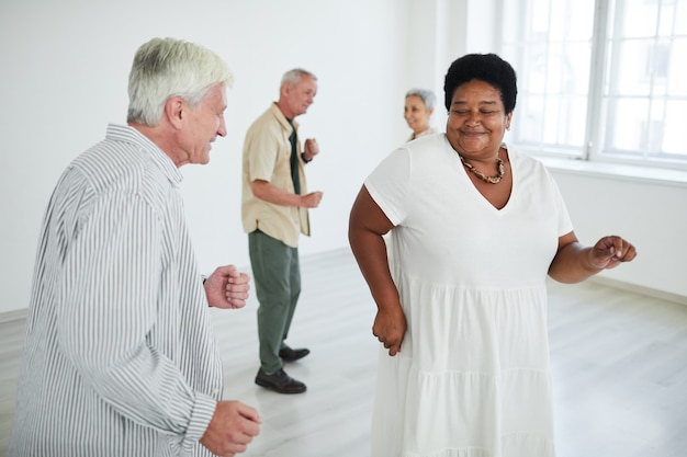 Group of happy senior people dancing together in dance studio