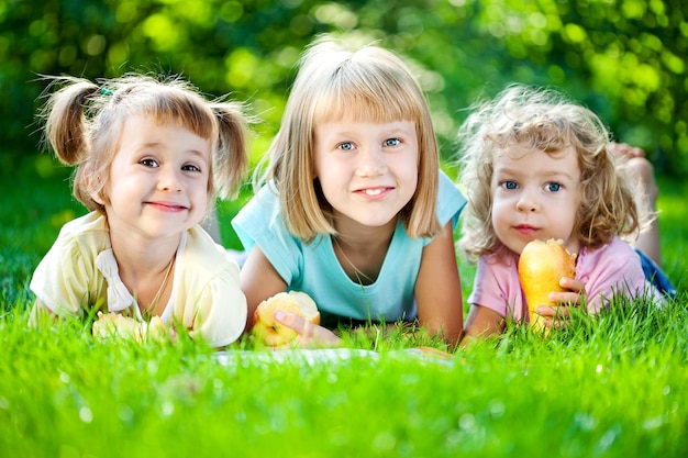 Gruppo di bambini sorridenti felici che giocano all'aperto nel parco di primavera