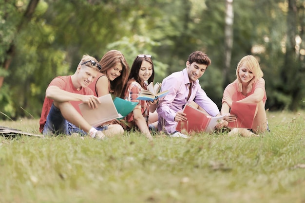 Group of happy students with books in the Park on a Sunny day