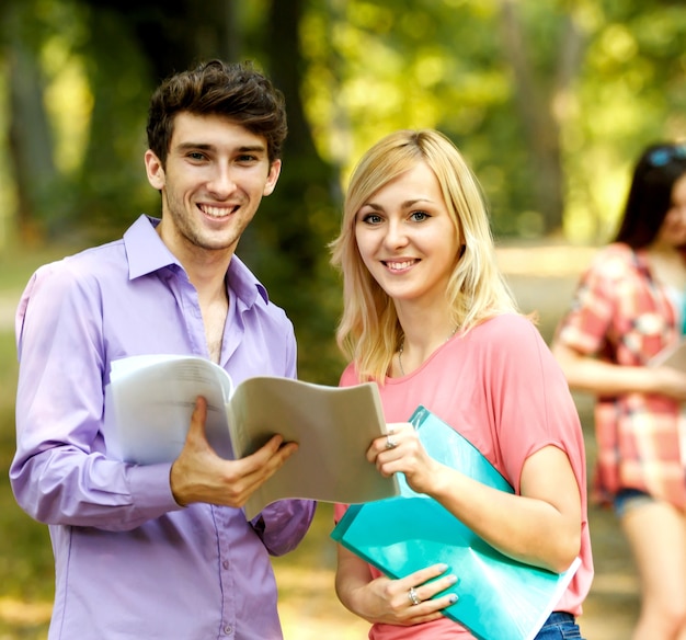 Group of happy students with books in the Park