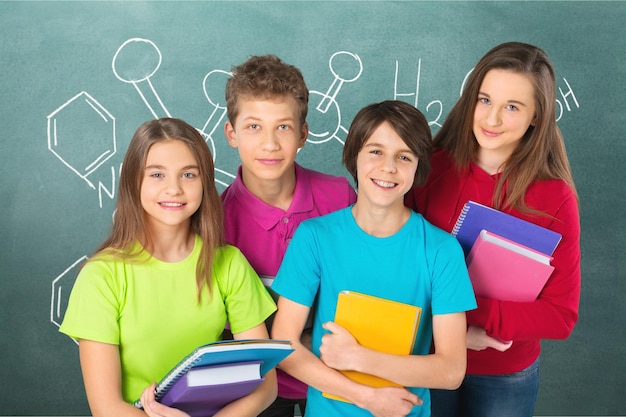本を持つ幸せな十代の学校の子供のグループ。孤立。