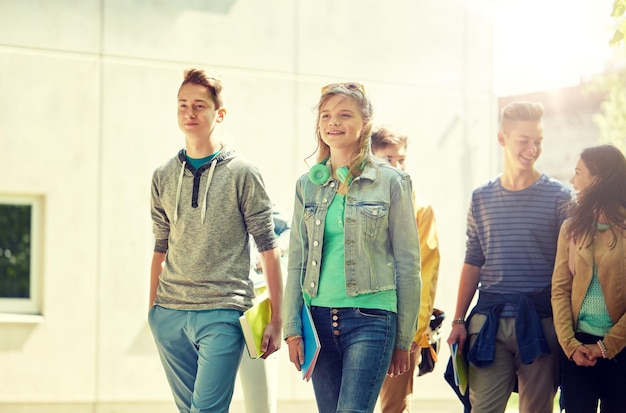 Photo group of happy teenage students walking outdoors