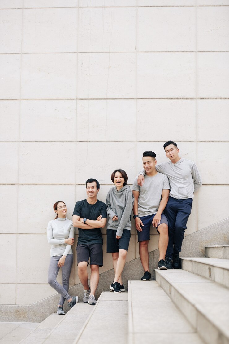 Photo 一群快乐的亚洲年轻人一起在户外慢跑后站在台阶上