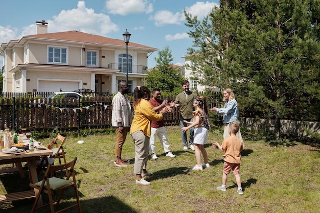 Group of happy young intercultural men and women clapping hands during game