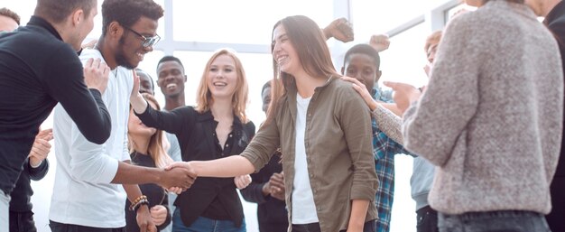 Group of happy young people congratulating their colleague  concept of success