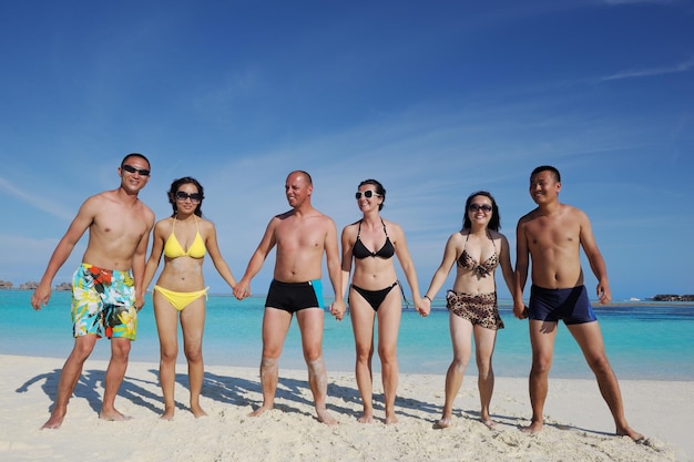 group of happy young people have fun and joy at the  white sand  beach on beautiful summer  day