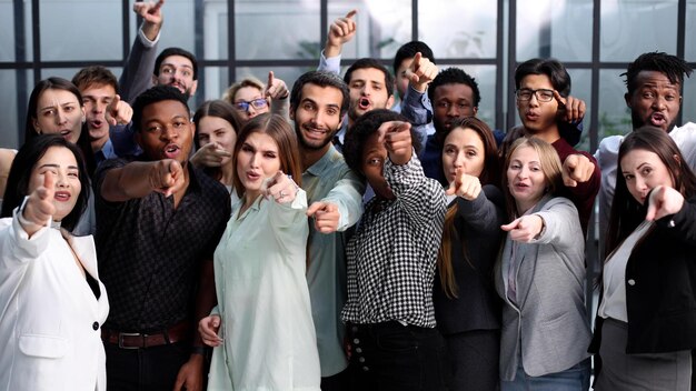 group of happy young people pointing at you