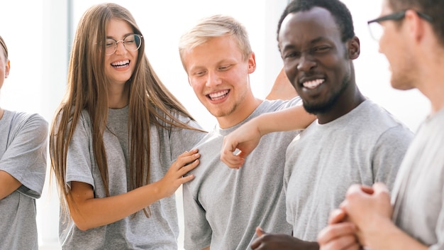 Group of happy young people standing in a bright room