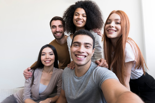 Foto gruppo di giovani felici che prendono un selfie