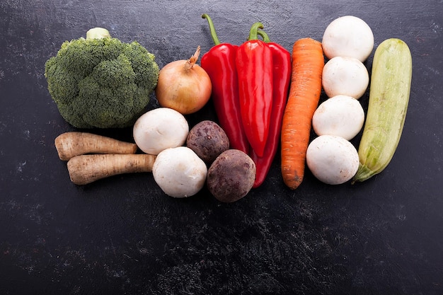 Group of healthy and fresh vegetables lying on dark wooden vintage board