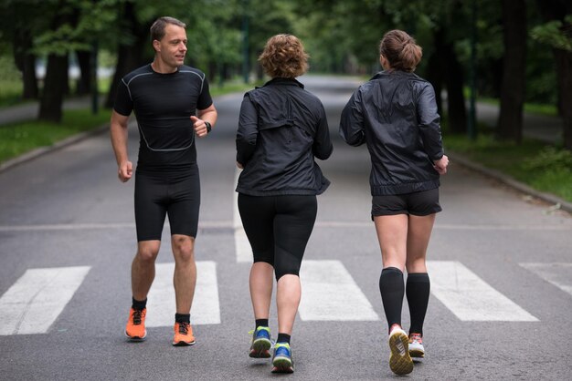 группа здоровых людей, бегающих в городском парке, команда бегунов на утренней тренировке