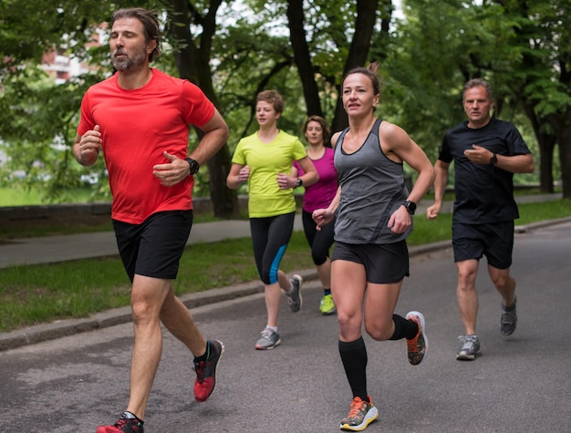 group of healthy people jogging in city park, runners team on morning training