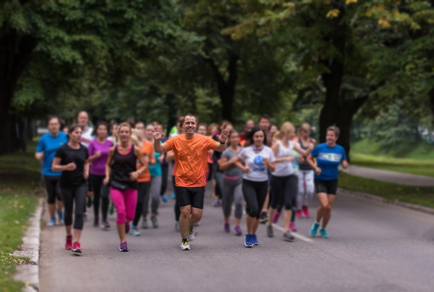 Foto gruppo di persone sane jogging nel parco della città, squadra di corridori sulla formazione mattutina