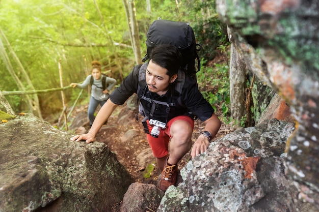 Group of hikers climbing up in forest