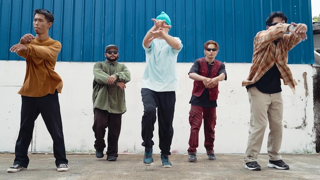 Group of hip hop choreographer dancing street dance together at wall Endeavor