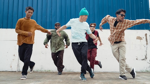Group of hip hop choreographer dancing street dance together at wall hiphop