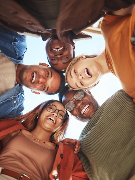 Group huddle portrait smile and hug below for community teamwork or trust together in the outdoors Happy people smiling in diversity for solidarity or unity for team support or friendship